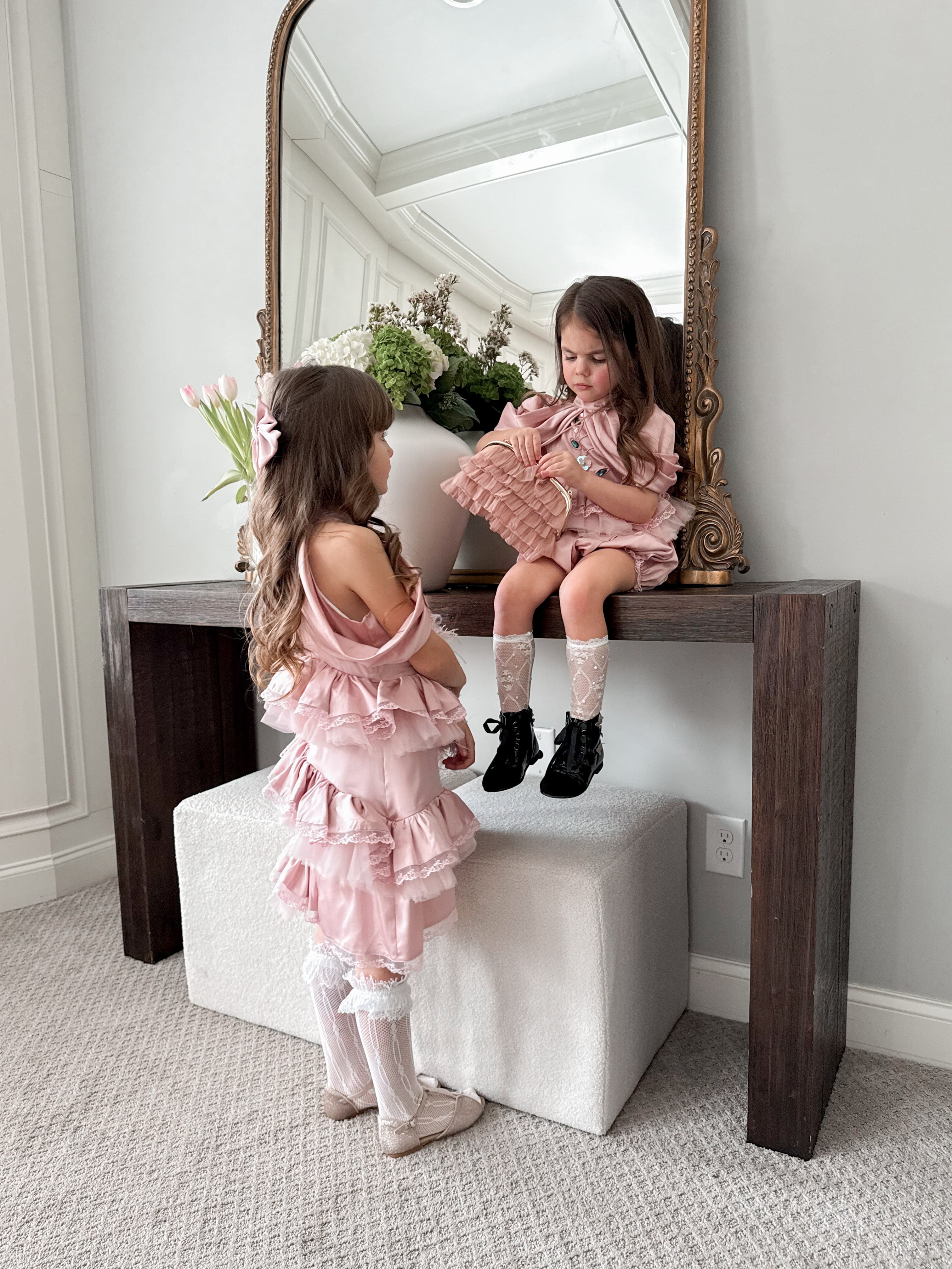 Pink satin ballerina dress shown from the back with flowing satin panels, soft lace trim, and ballet inspired detailing