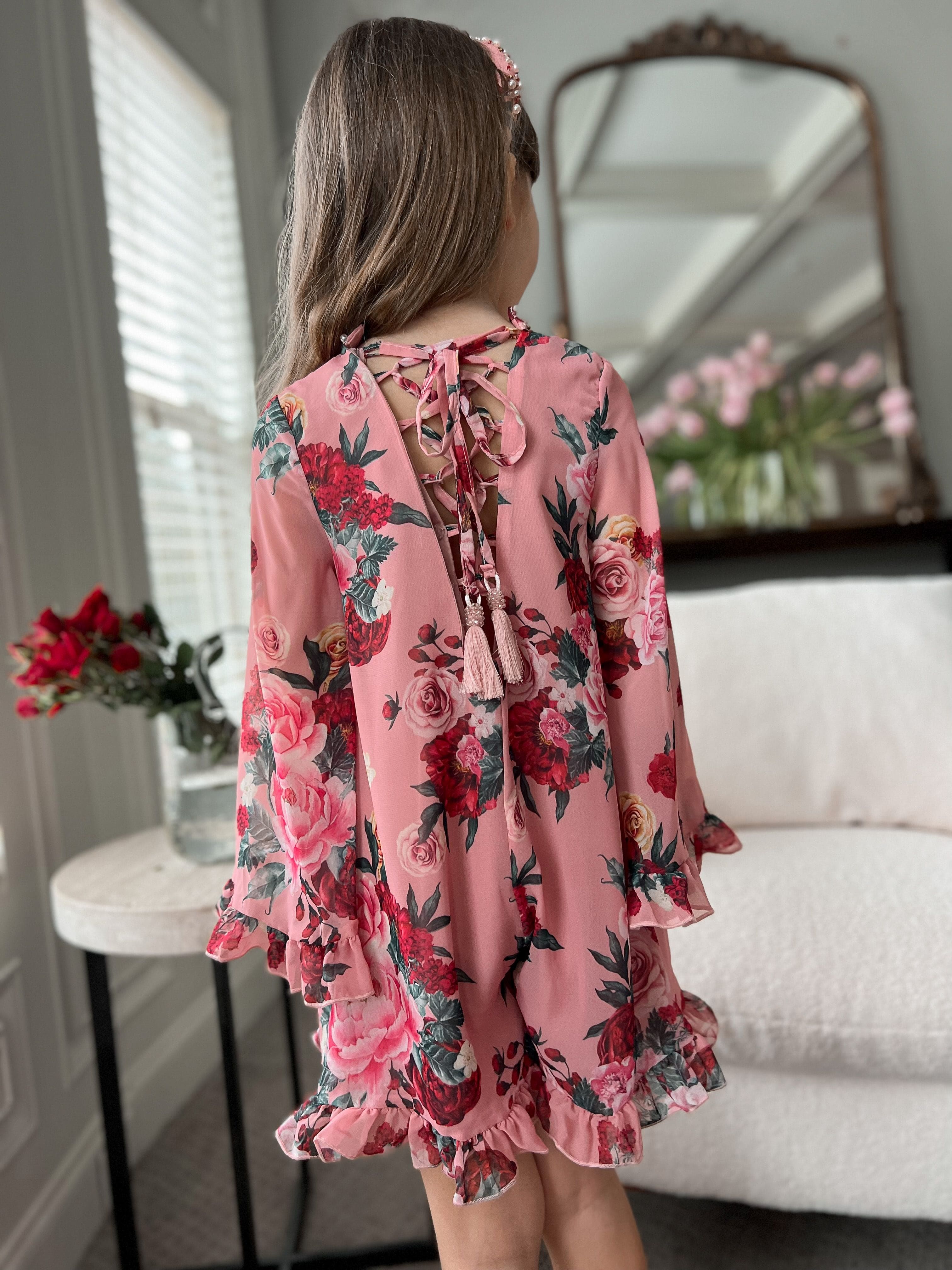 Back view of Flora flower print jumpsuit showing floral pattern, ruffle hem, sand tie back detail