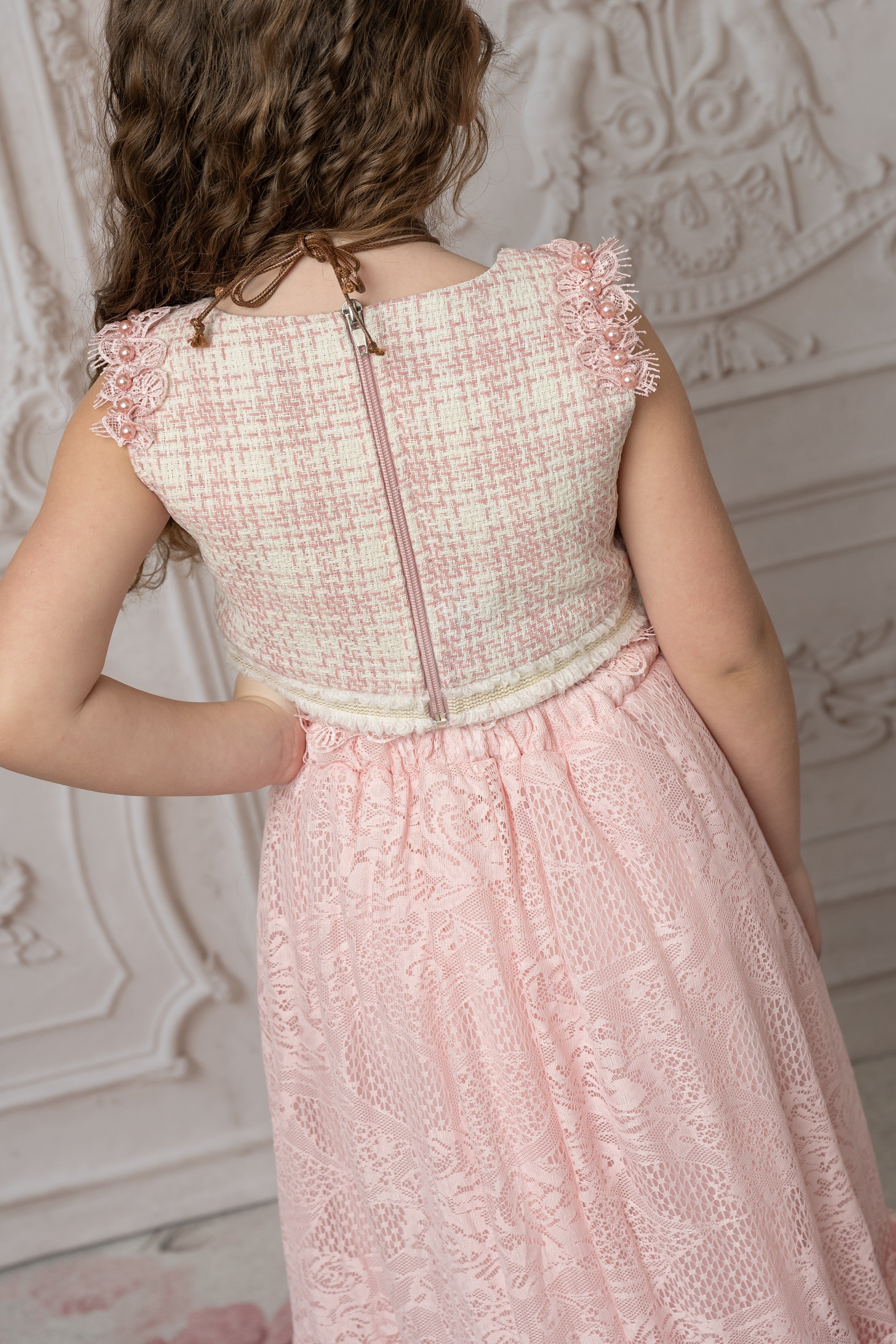 Back view of girls beige and pink tweed top and pink lace ruffle skirt