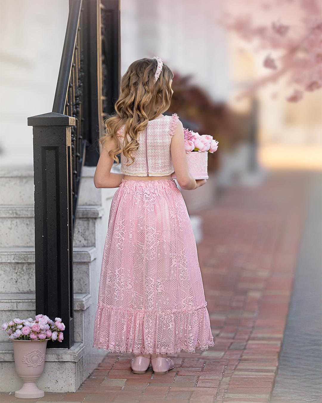 Back view of girls formal beige and pink tweed sleeveless top and pink ruffle skirt