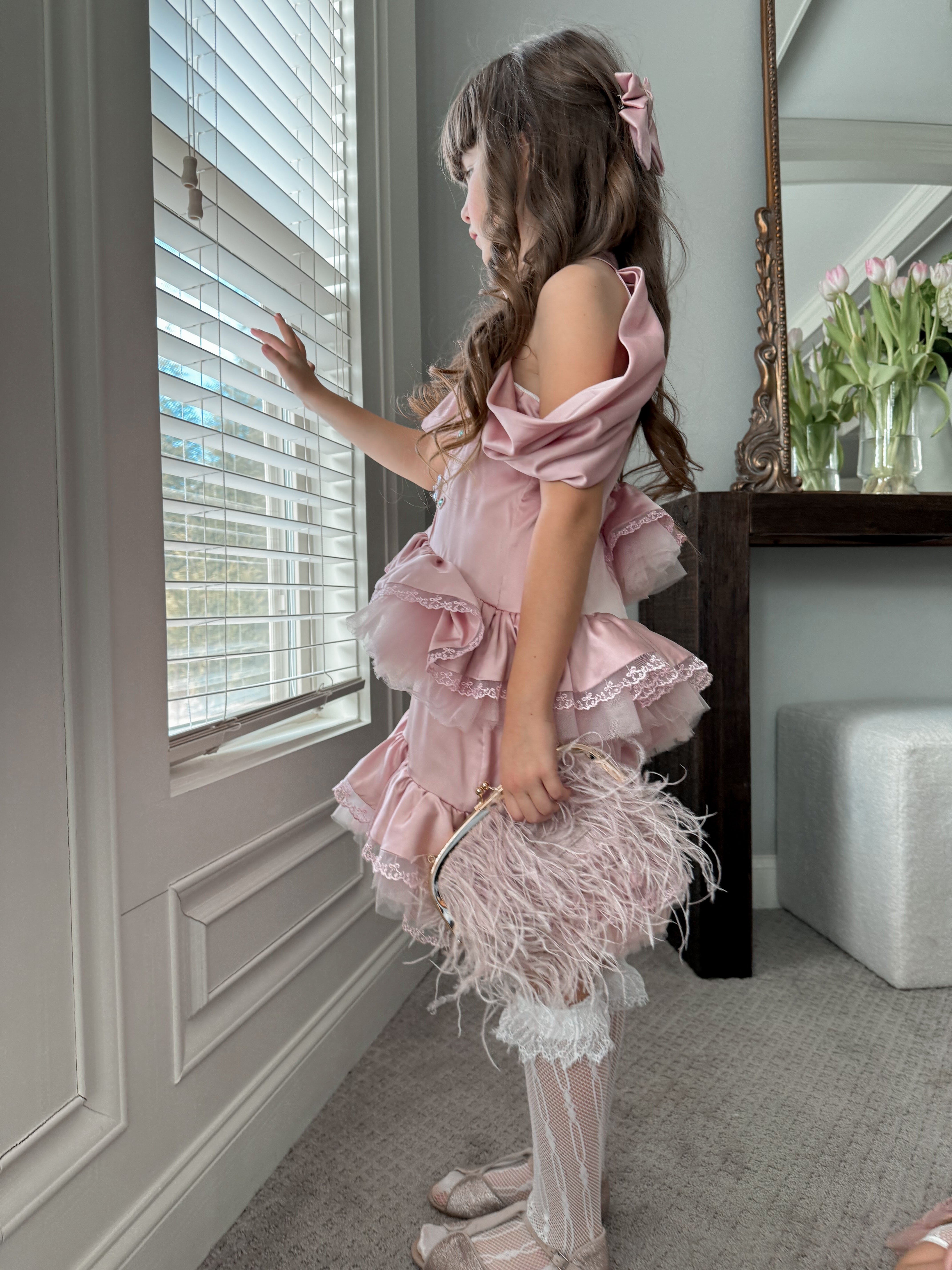 Girl wearing a pink satin ballerina dress with layered ruffle skirt and off the shoulder neckline