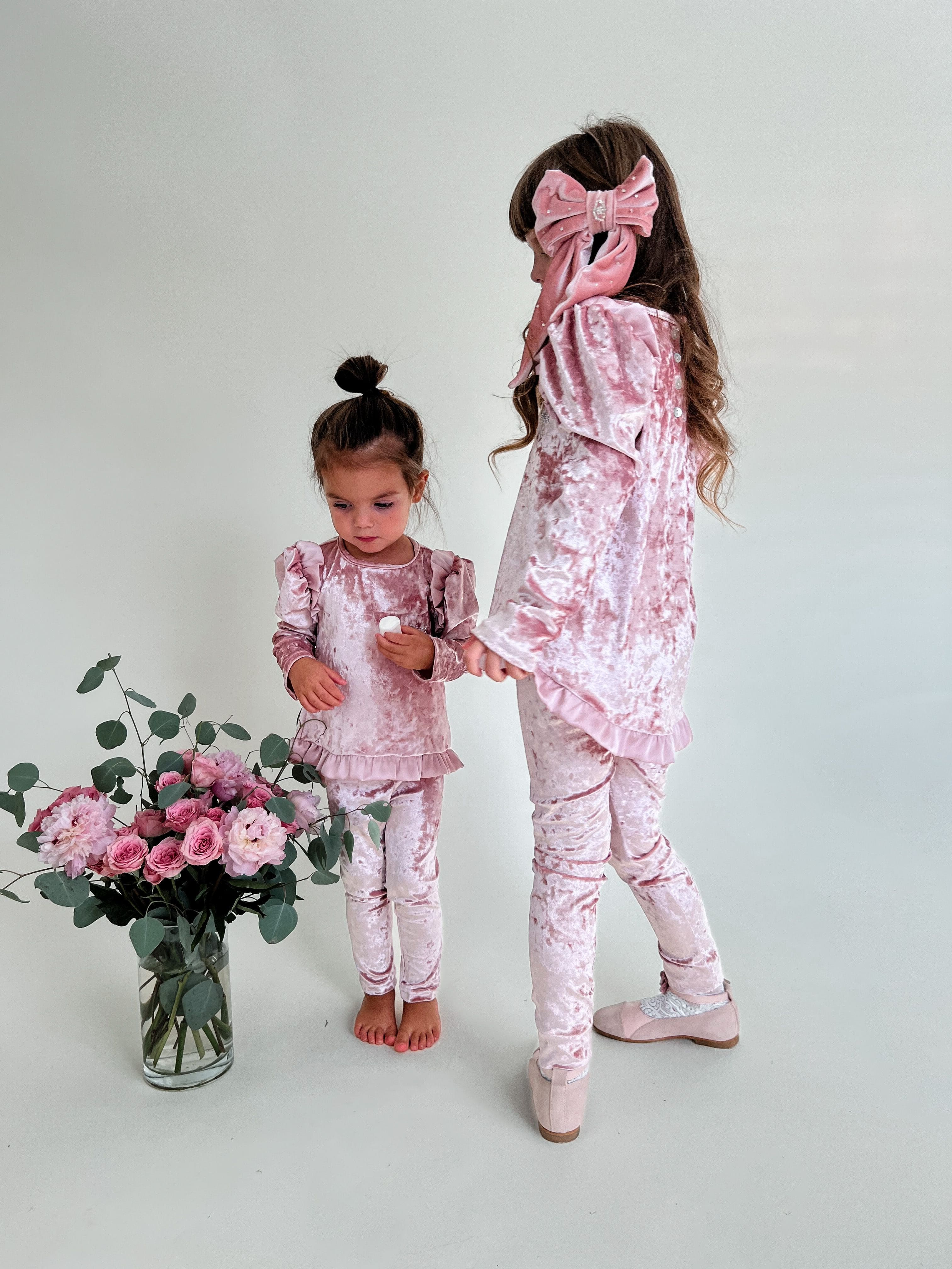 Back view of pink velour lounge set with long sleeve ruffle top and slim fit leggings, luxury girls matching outfit