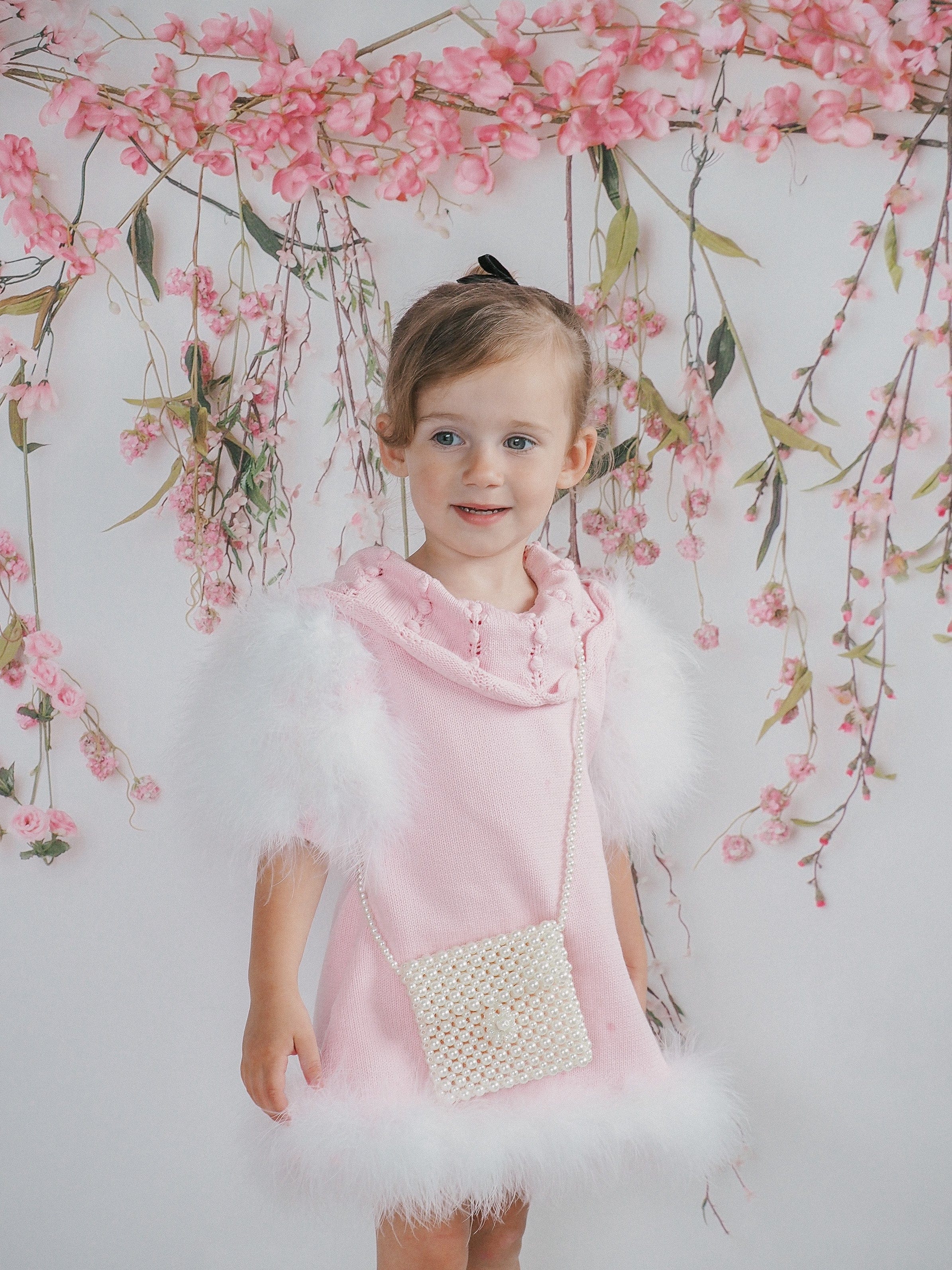 Child modeling Ella Knit Pink Feather Dress front shot featuring statement collar and elegant fit