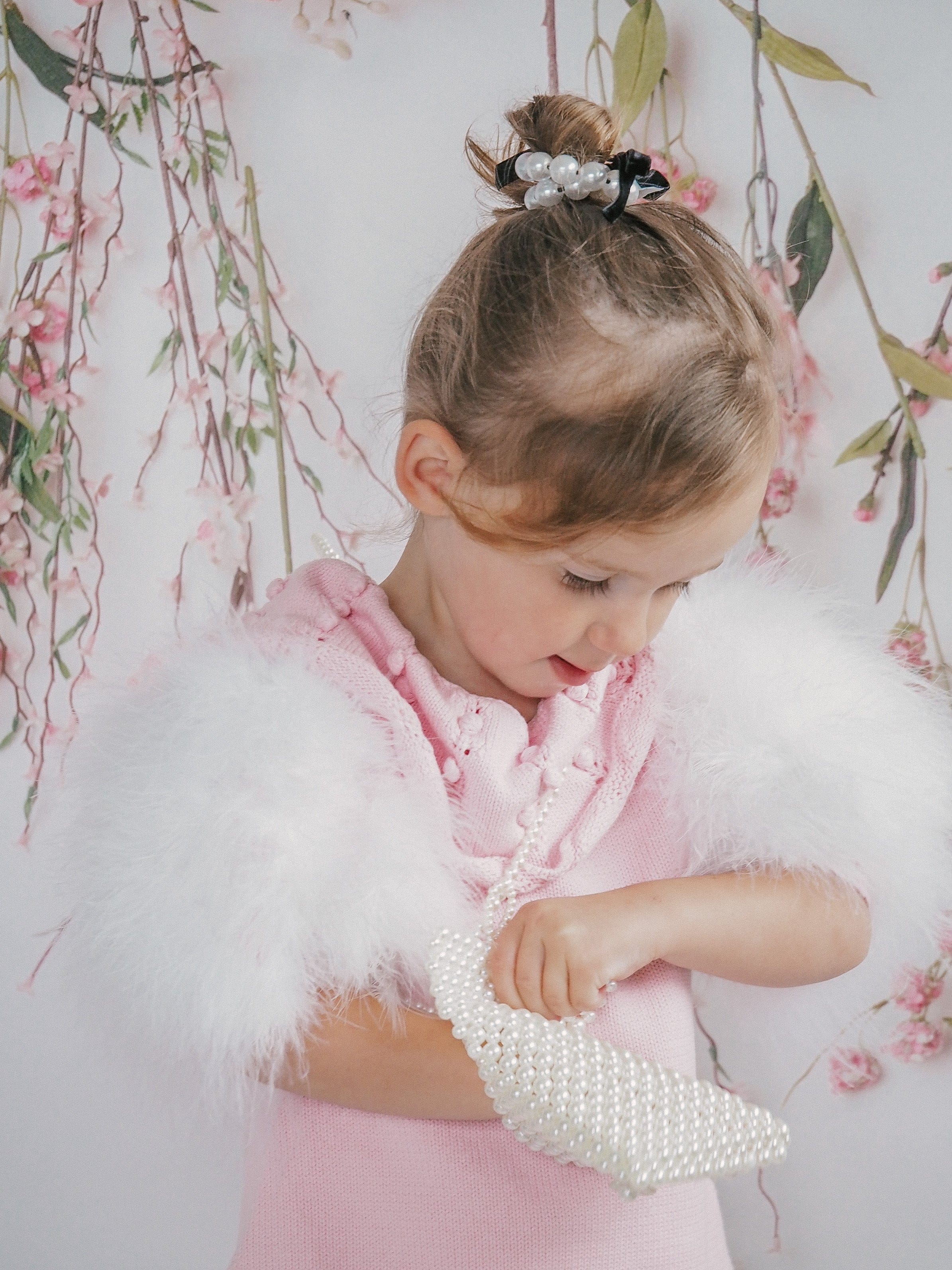 Close up of Ella Knit Pink Feather Dress on little girl showing luxury knit fabric and feather sleeve trim