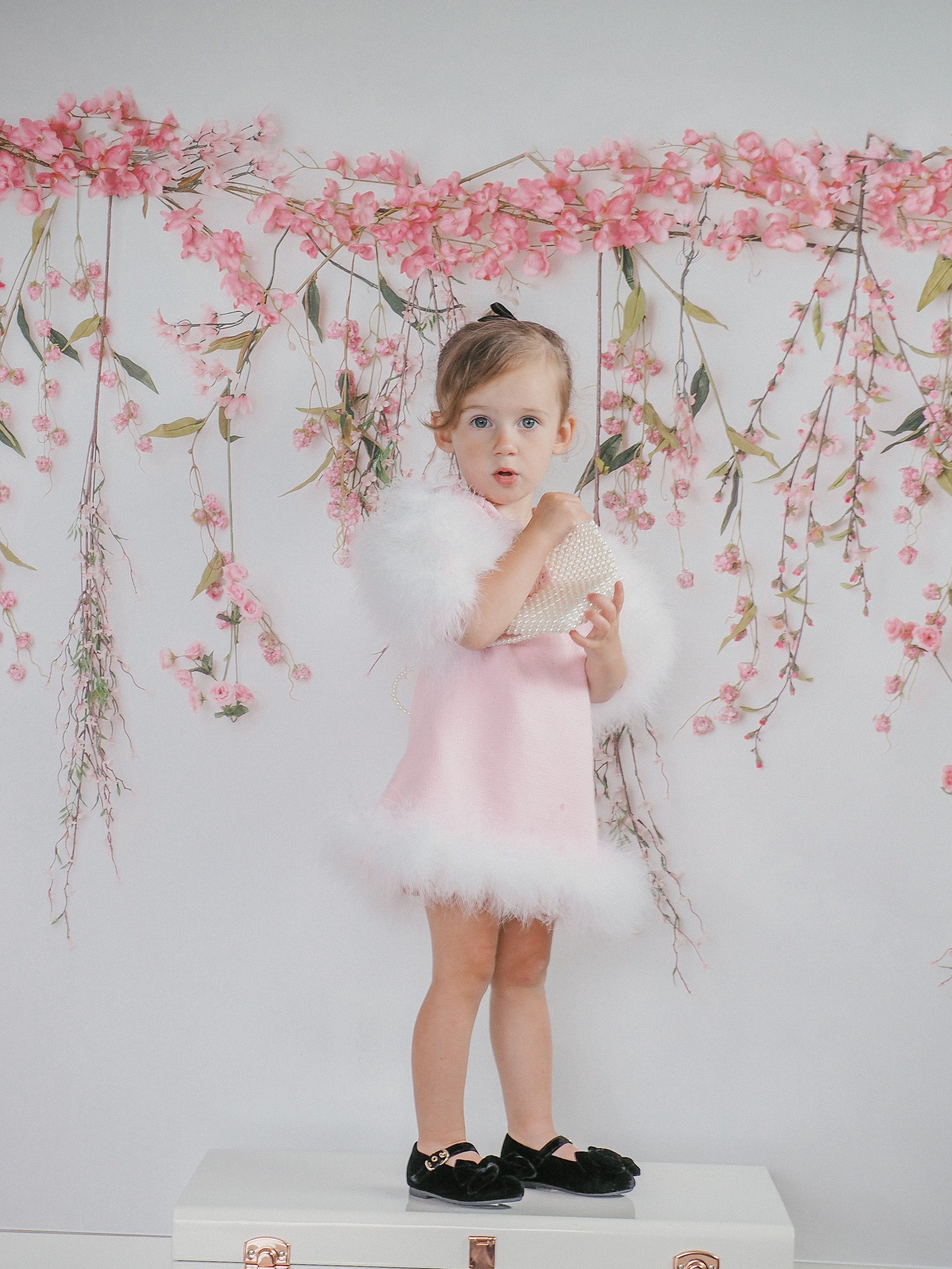 Front view of Ella Knit Pink Feather Dress modeled by young girl highlighting knit texture and neckline detail