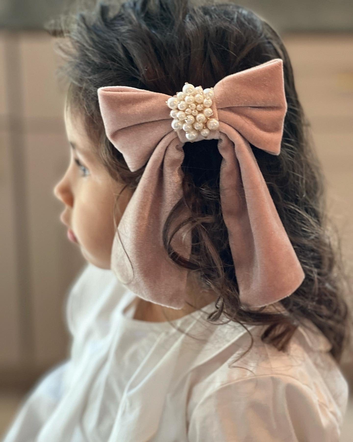 Girl wearing Dusty Pink Velvet Hair Bow with soft pink outfit, elegant velvet statement bow for dressy events