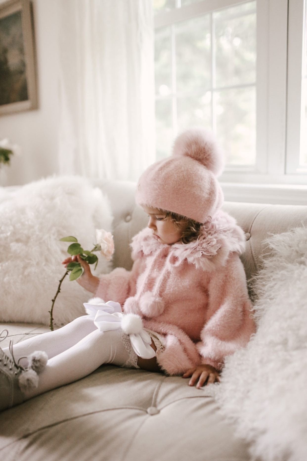 Little girl wearing Milana Rose Beret in blush pink with pom pom, styled indoors with neutral winter outfit.