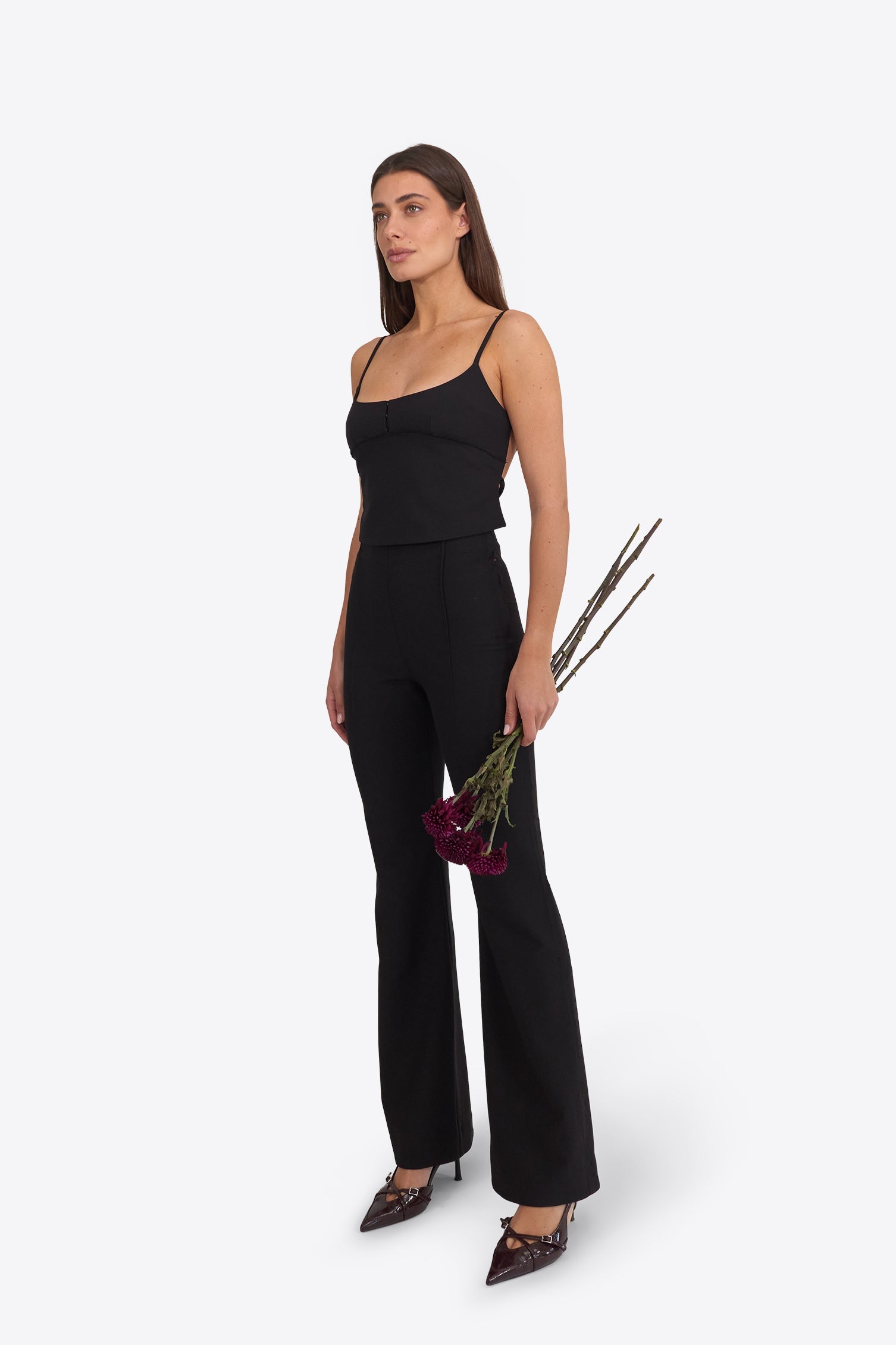 a high-rise soft-flared pant and a structured open-back top in black