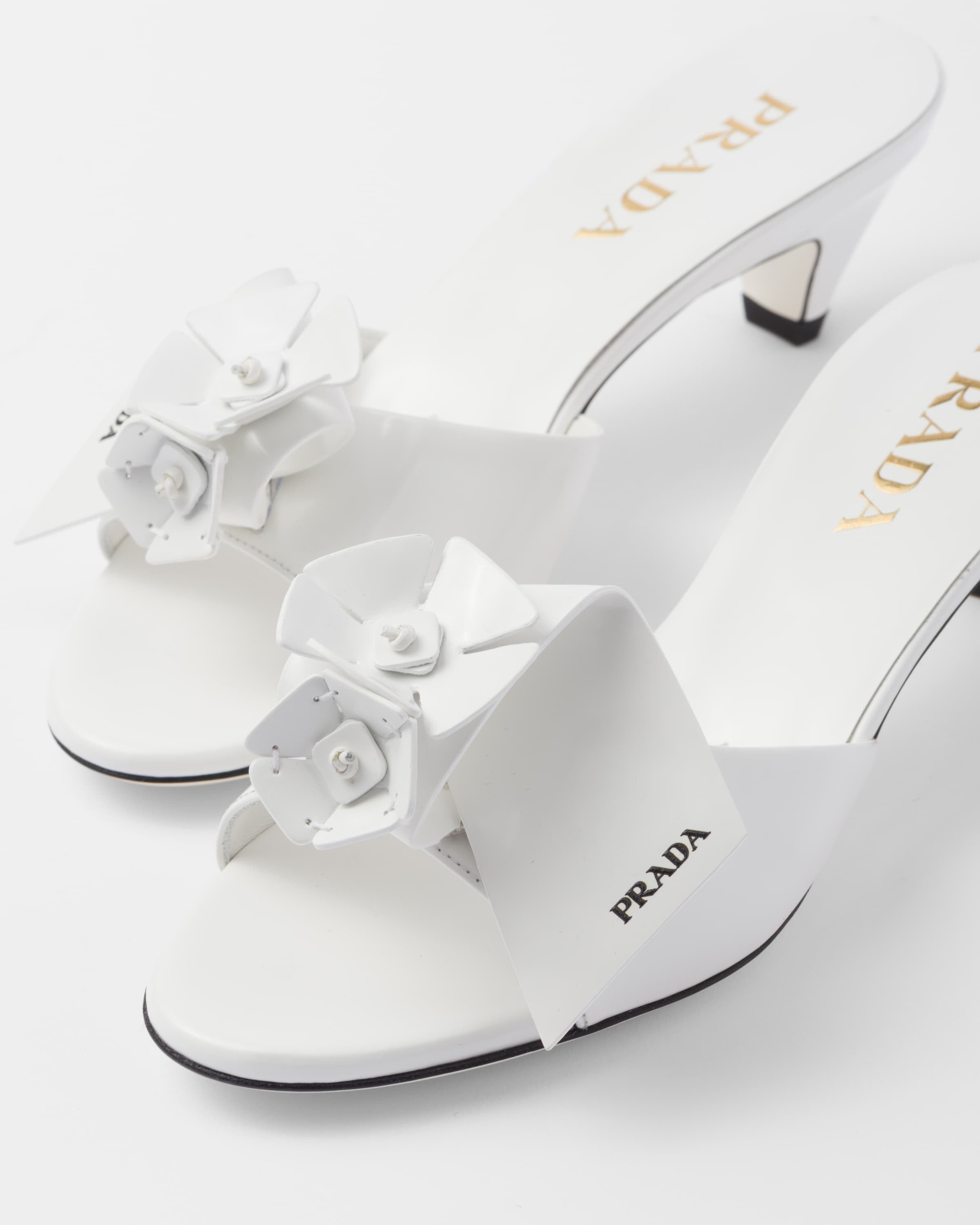 Bianco patent leather heeled mules with prada logo