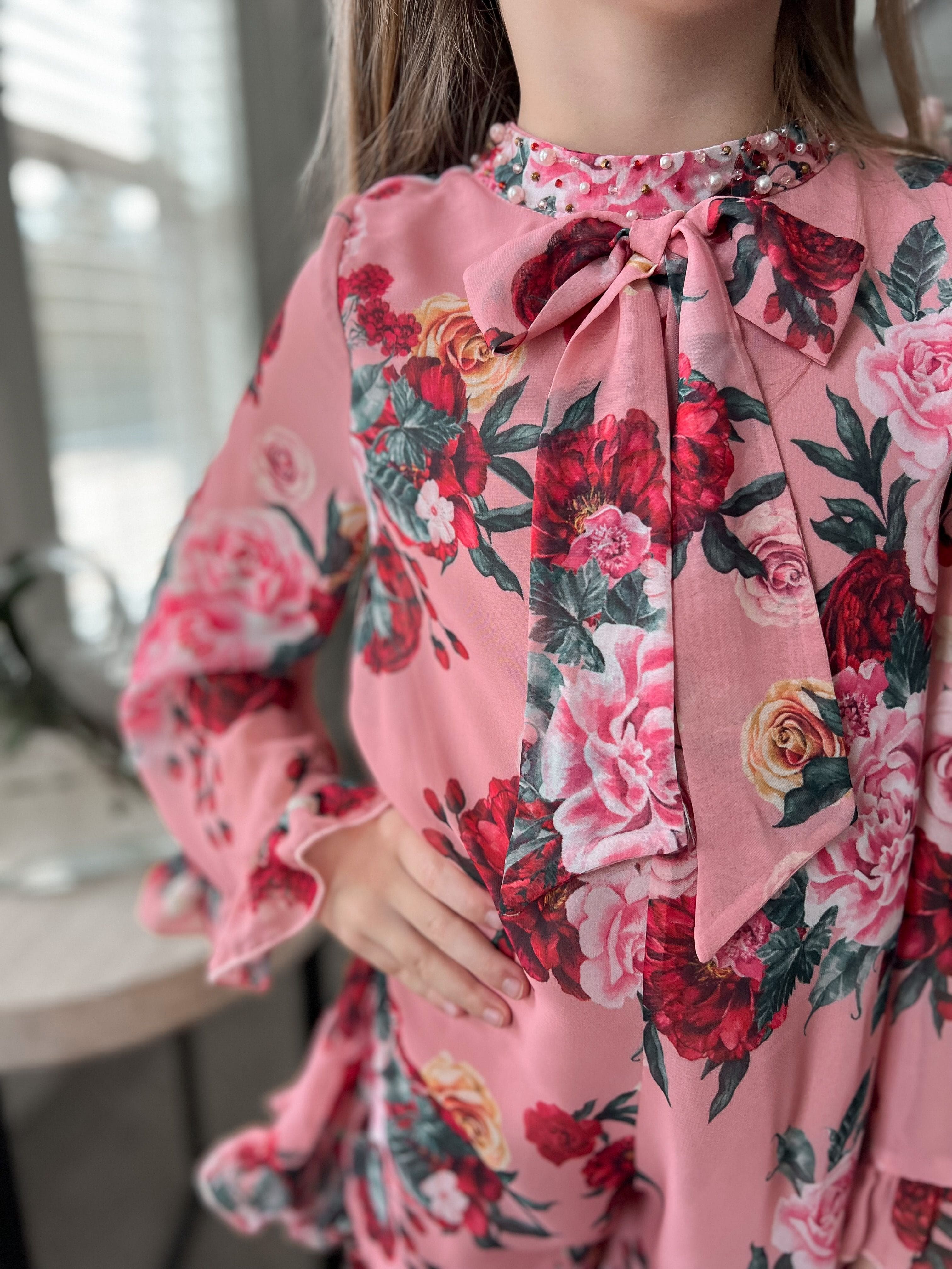 Front detail of Flora flower print jumpsuit showing floral print, gathered neckline, and tie accent