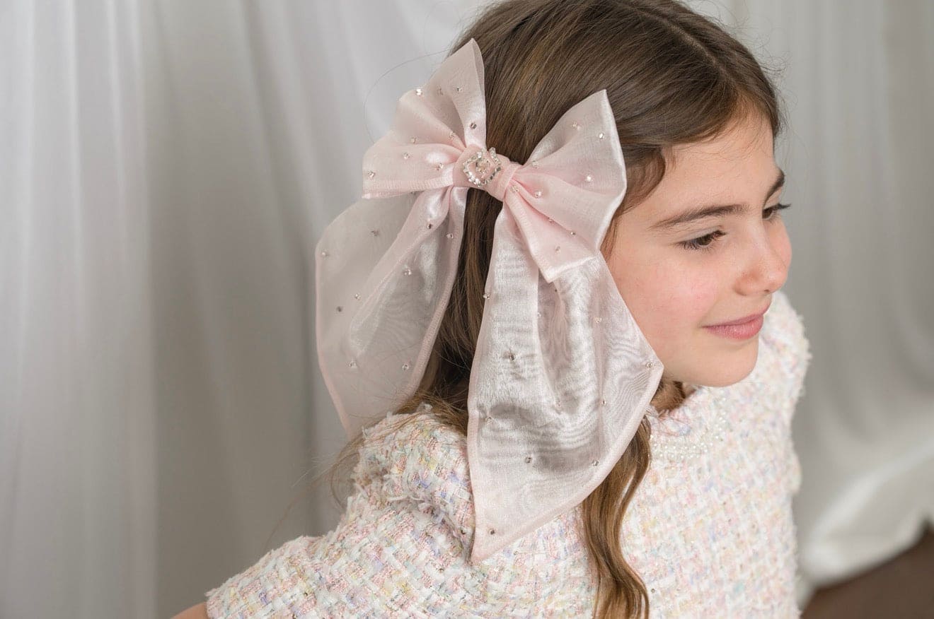 Little girl wearing the Juliette Pink Organza Hair Bow with long flowing organza tails and pearl accents for a special occasion look.
