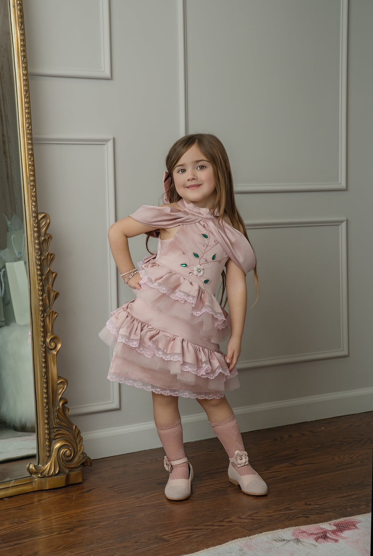 Pink satin ballerina dress with embroidered bodice and tiered lace trim skirt, styled for a classic children's portrait 