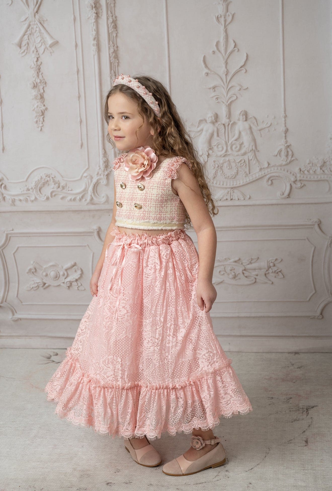 Luxurious girls pink and white tweed top and lace skirt set with gold embellished buttons, pearl fringe trim, and refined details for special occasions.