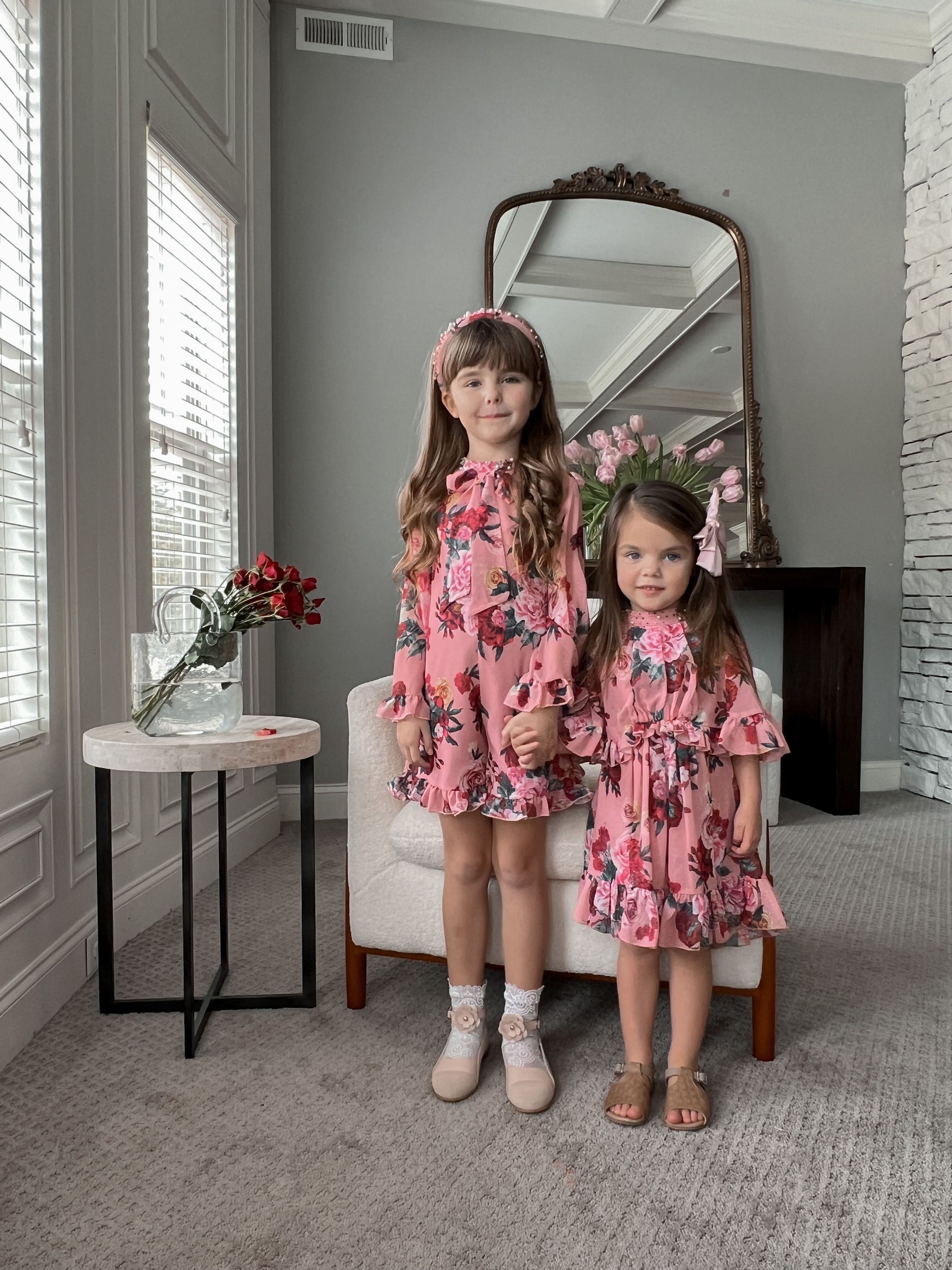 Girls styled indoors wearing Flora flower print jumpsuit in pink floral design for special occasions 