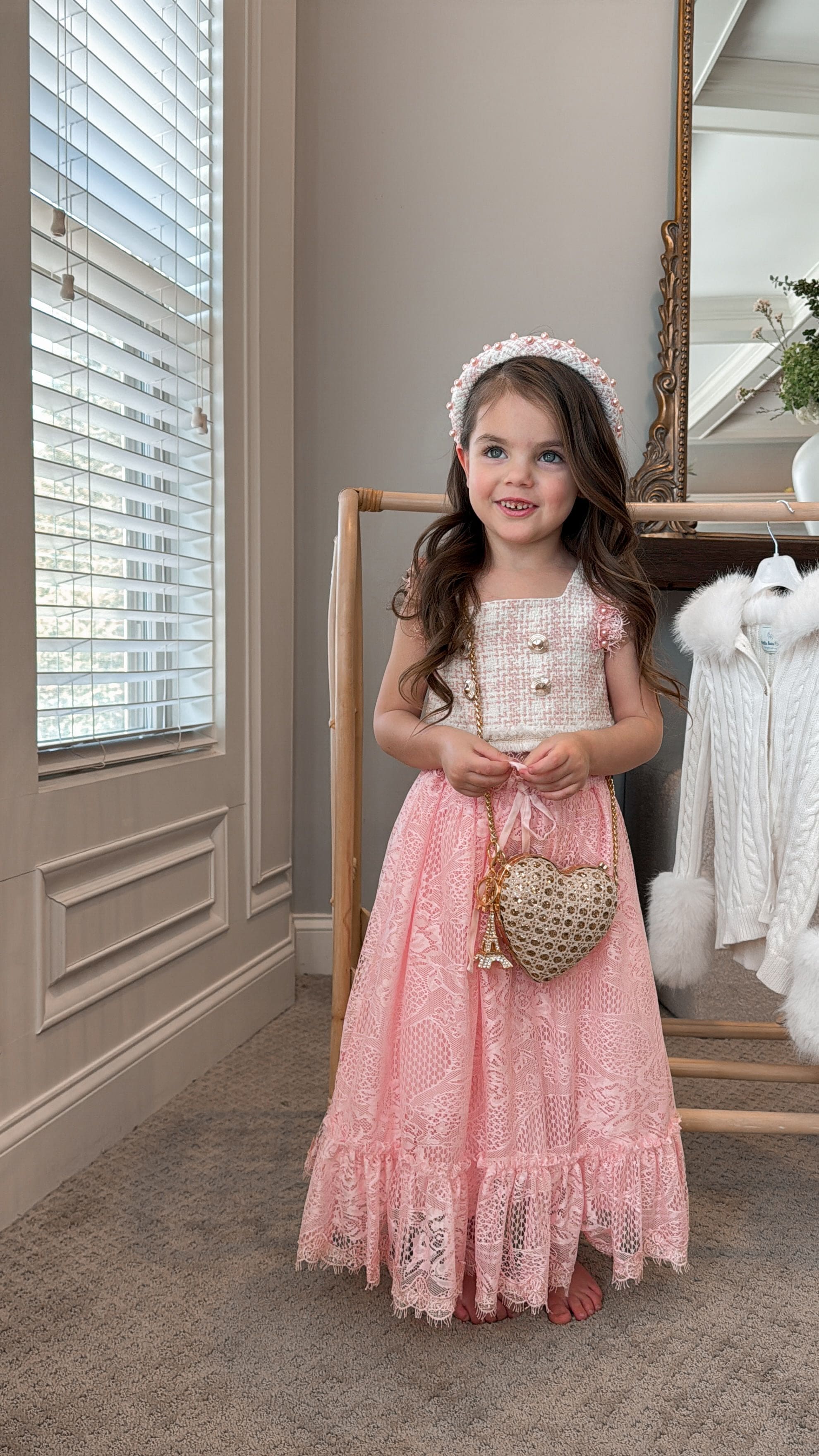 Girl wearing beige and pink tweed top with a matching pink skirt styled with a headband and heart shaped purse