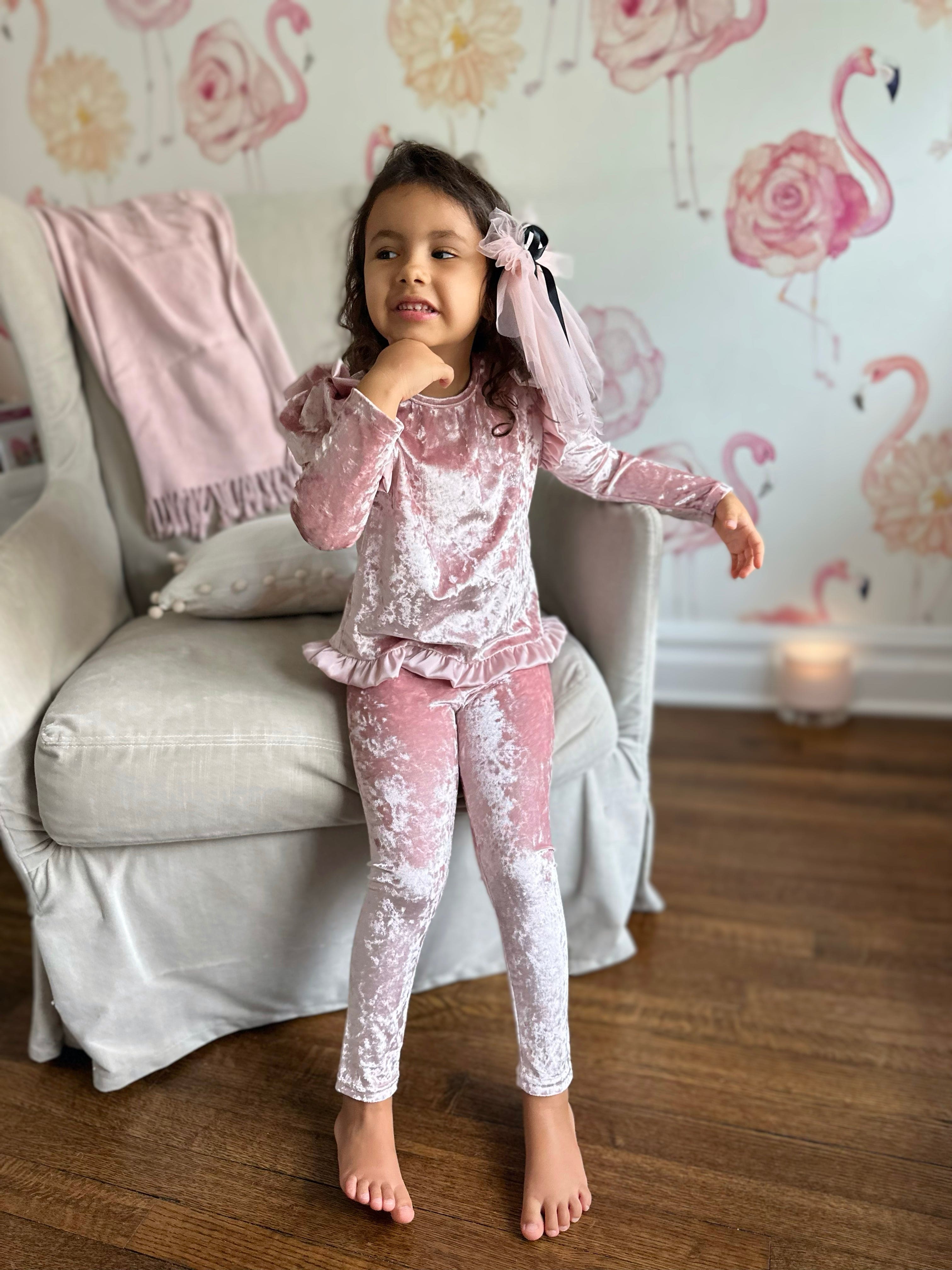 Young girl wearing pink velour lounge set with soft velvet texture and ruffle hem detail