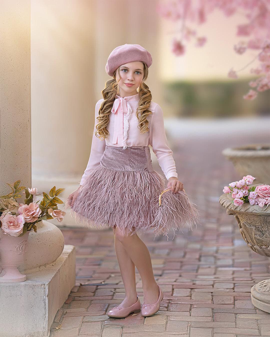 Blush pink girls outfit with bow blouse, matching skirt, feather purse, and pink beret