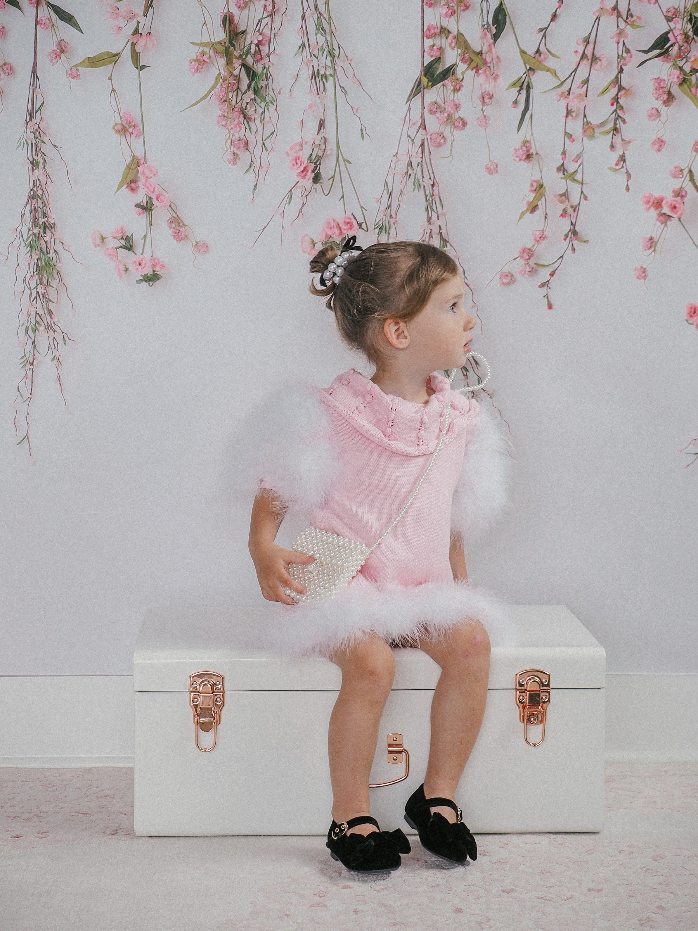 Child modeling Ella Knit Pink Feather Dress front shot featuring statement collar and elegant fit