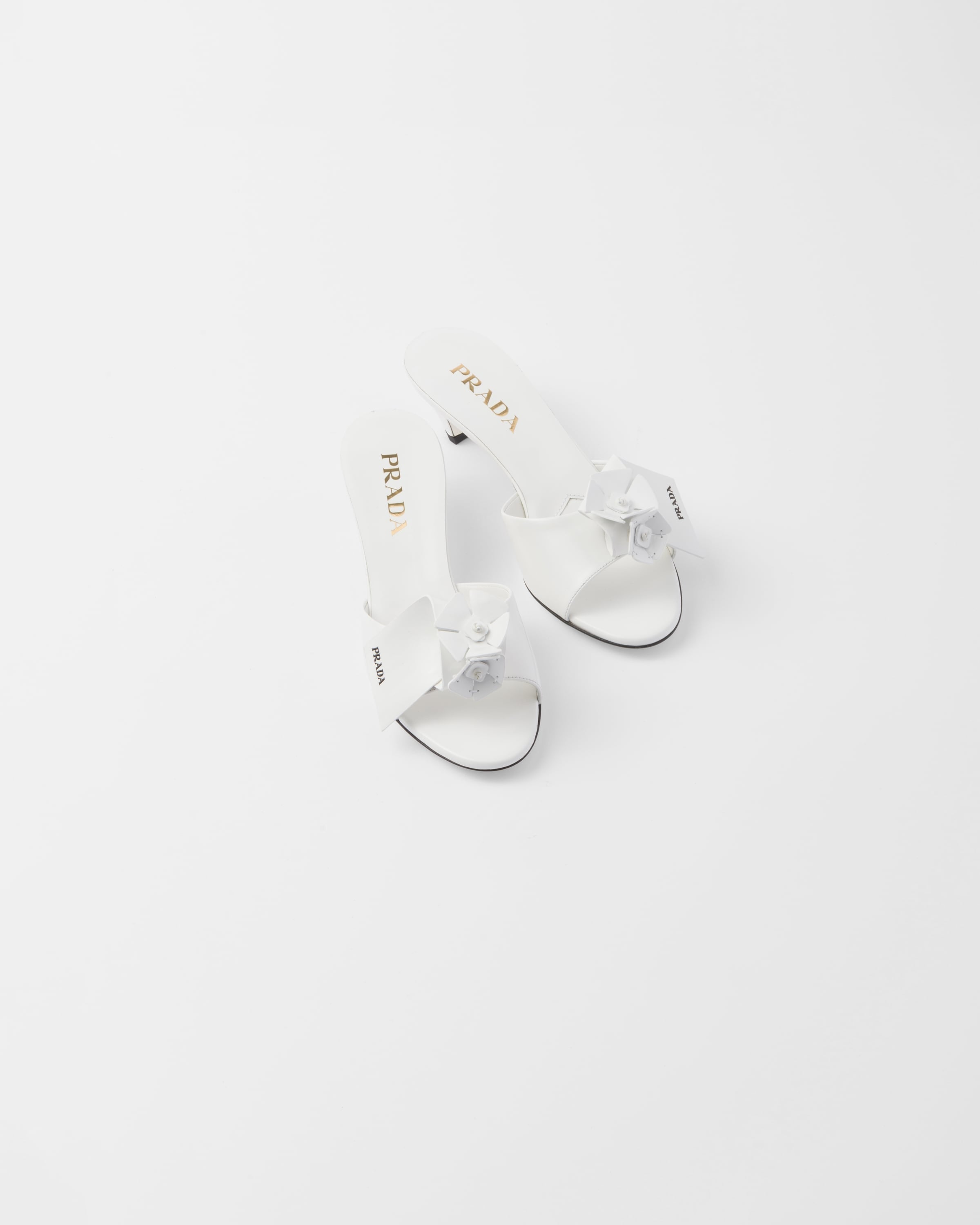 Bianco patent leather heeled mules with prada logo