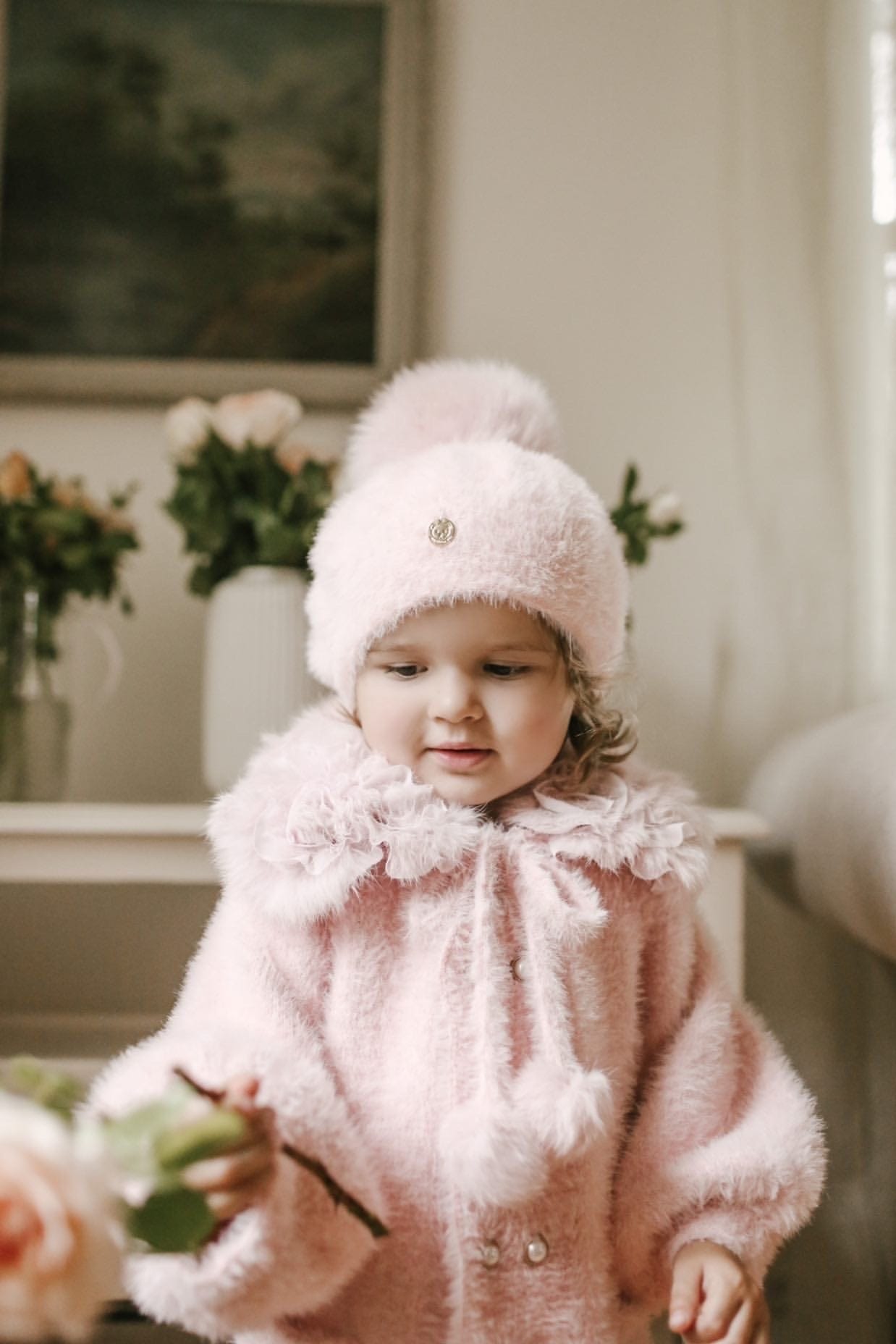 Little girl wearing Milana Rose Beret in soft blush pink with faux fur pom pom for winter photoshoot styling.