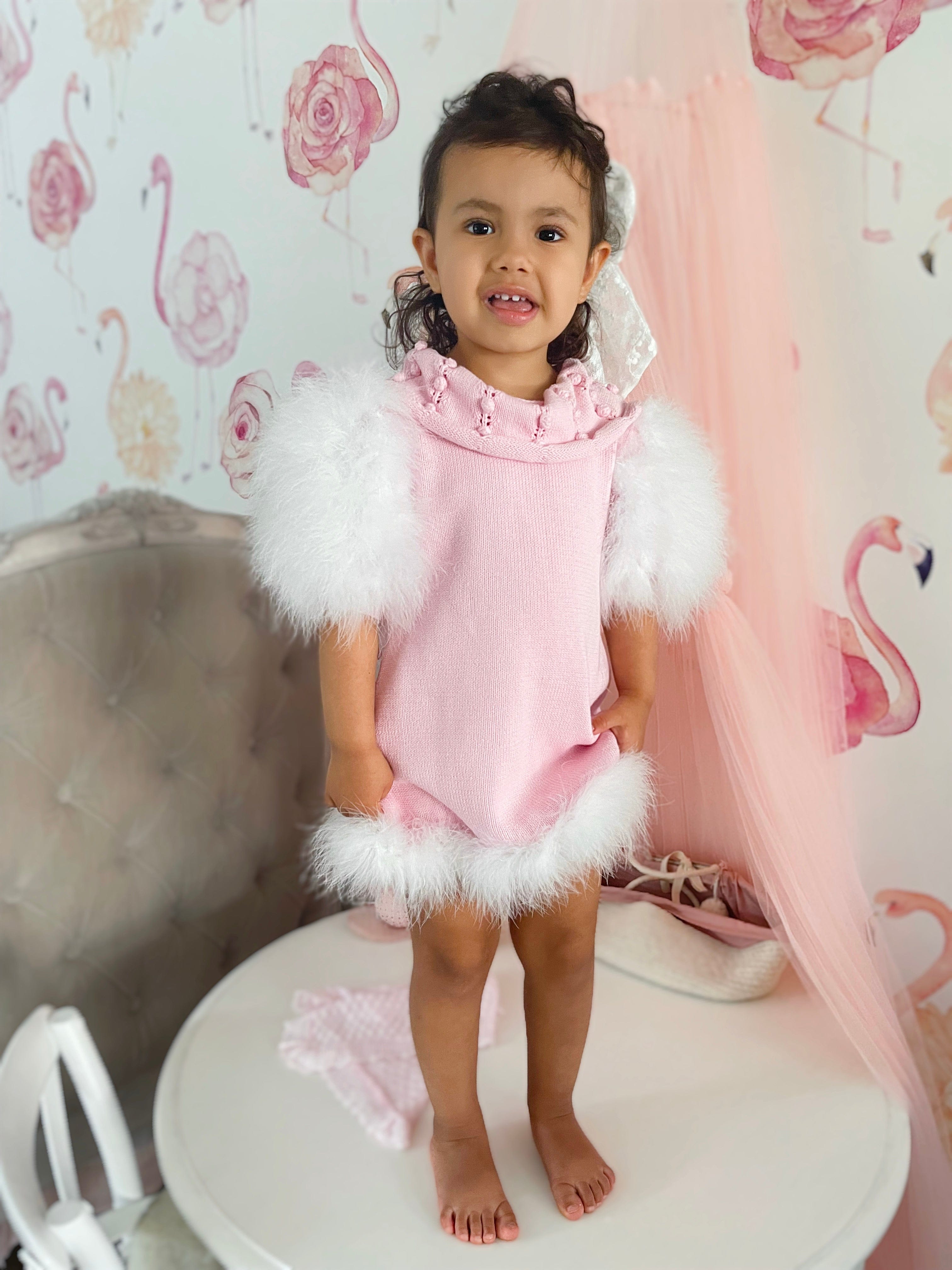 Child modeling Ella Knit Pink Feather Dress front shot featuring statement collar and elegant fit