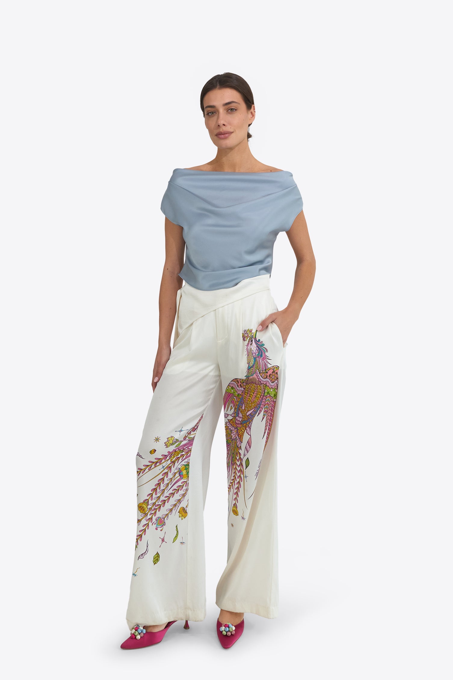 Du & Berry Phoenix Belted Silk Trousers in white with colorful phoenix print, worn with blue top and pink shoes